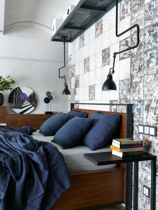 带有海军蓝床单的工业风格阁楼卧室