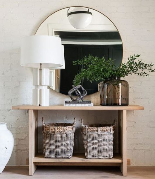 light-wood entryway table with elegant minimalism circular brass mirror